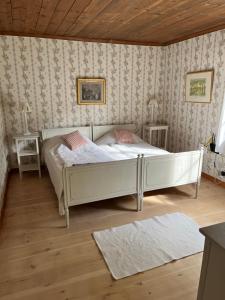 a bedroom with a white bed and two tables at Romantic Villa in historic setting with lake view in Säffle