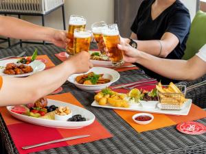a group of people sitting at a table with beers at Ibis Saigon Airport in Ho Chi Minh City