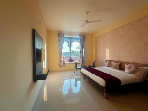 a bedroom with a large bed and a window at Vijayam Resort in Nāthdwāra