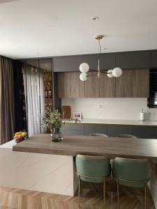 a kitchen with a wooden table and green chairs at Comfort Hotel & villas in Donji Štoj