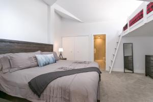 Un dormitorio con una cama grande y una escalera en Tantalus Penthouse Mountain and Village Views, en Whistler