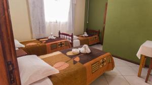 a room with three beds with towels on them at Pousada bonomo in Urubici