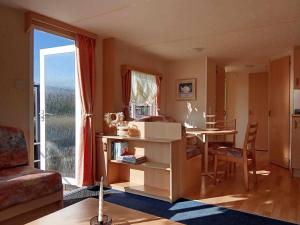 a living room with a table and a dining room at Stacaravan aan het water 2 in Earnewâld
