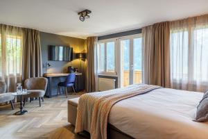 a hotel room with a bed and a desk at Boutique Hotel Panorama Grindelwald in Grindelwald