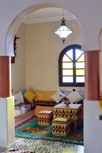 una sala de estar con un sofá y una mesa en Riad Aïcha Addi - Poolside - Traditional Moroccan, en Essaouira