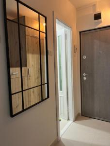 un espejo en una pared al lado de una puerta en One Room Apartment- Self Check-in 24h, en Reşiţa