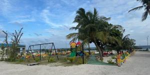 a playground on a beach with palm trees at Kendhoo holidays in Kendhoo