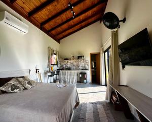 a bedroom with a large bed and a kitchen at Canastra - Chalés Canário de Minas in São João Batista do Glória +65 photos