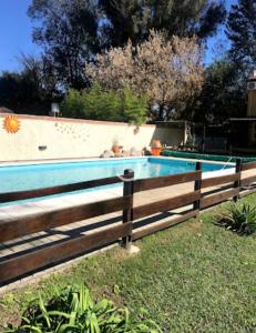 a swimming pool with a wooden fence around it at cabañas el viejo ciprés 3 in Santa Rosa de Calamuchita