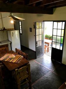 a dining room with a table and chairs and a door at cabañas el viejo ciprés 3 in Santa Rosa de Calamuchita