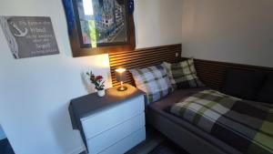 a small bedroom with a bed and a nightstand with a lamp at Wohnung Schlossblick in Celle