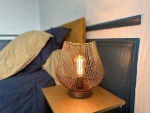 a lamp sitting on a table next to a bed at L'Amphore du clos de Bigos in Soussans
