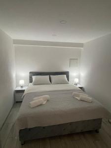 a bedroom with a large bed with two towels on it at Apartman Mole in Livno +4 photos