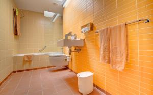 Baño de azulejos amarillos con aseo y lavamanos en SBH Monica Beach Resort, en Costa Calma