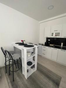 a white kitchen with a table and two chairs at Apartman Mole in Livno