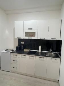 a kitchen with white cabinets and a sink at Apartman Mole in Livno