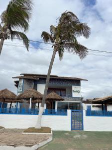 two palm trees in front of a building at Pousada Bedoya in Nísia Floresta +10 photos