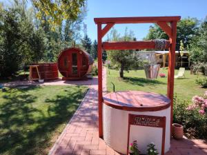 een picknickplaats en een vuilnisbak in een tuin bij Hídláb Apartman in Kimle