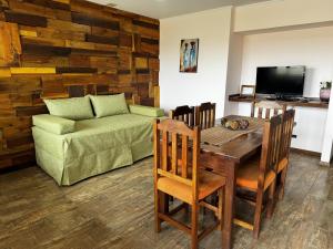 a living room with a table and a couch at Patagonia Austral Suites - Cabaña con servicio de hotel - DESAYUNO INCLUIDO! in El Calafate