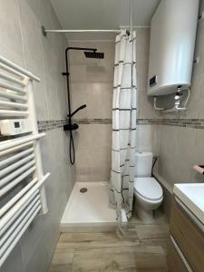 a bathroom with a shower curtain and a toilet at Studio Wood Bay in La Grande-Motte
