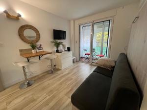 a living room with a couch and a desk at Studio Wood Bay in La Grande-Motte