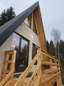 a house with a large window and a wooden ramp at Altundeva la munte in Podu Dîmboviţei
