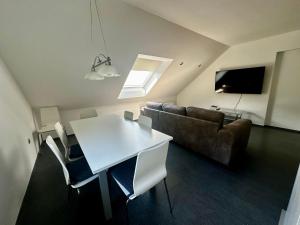 a living room with a white table and a couch at Apartment and rooms Špes in Mislinja
