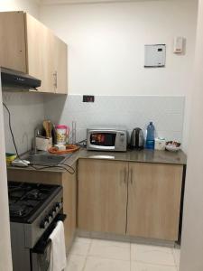 a kitchen with a stove and a microwave at Kiambu Heights one Bedroom in Nairobi