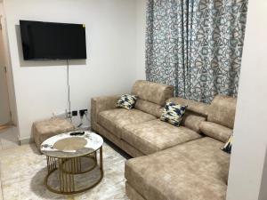 a living room with a couch and a table at Kiambu Heights one Bedroom in Nairobi