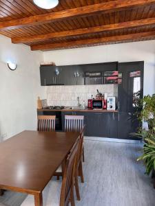 a kitchen and dining room with a wooden table and chairs at Accommodation Casa Luca in Horezu