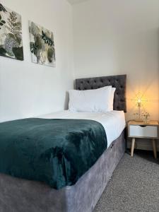 a bedroom with a large bed and a side table at Star Road Home, central location, FREE parking in Peterborough