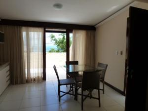 a dining room with a glass table and chairs at Flat Vila 4 Amigos in Natal