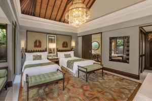 a bedroom with two beds and a chandelier at The St. Regis Bali Resort in Nusa Dua