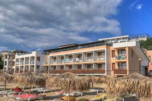 a hotel with chairs and umbrellas on the beach at SeaInn in Obzor