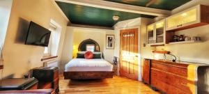 een slaapkamer met een bed en een flatscreen-tv bij Le Ricochet Urbain in Québec