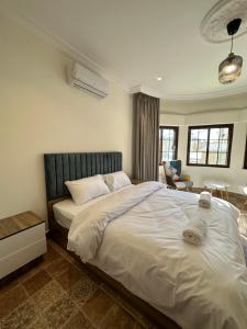 a bedroom with a large white bed and a chair at 10 Antica jabalal-lwebdeh in Amman