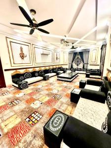 a living room with couches and a ceiling fan at Emerald Villa Swat in Ghurejo +56 photos