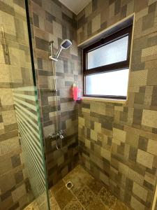 a bathroom with a glass shower with a window at 10 Antica jabalal-lwebdeh in Amman