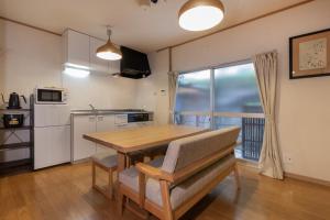 a kitchen with a wooden table and a dining room at Shiki Homes HIKARI in Kyoto