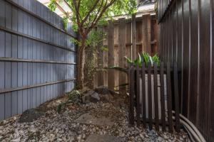 a fence with a tree in front of a fence at Shiki Homes HIKARI in Kyoto