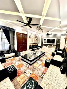 a living room with black couches and a ceiling at Emerald Villa Swat in Ghurejo