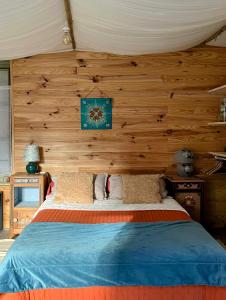 a bedroom with a bed with a wooden wall at Vivez dans un magnifique village Normand gîte de la Halle in La Carneille