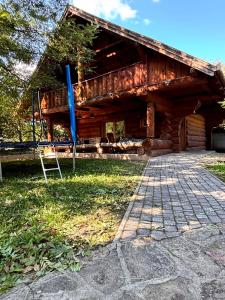a swing in front of a log cabin at Levendula Resort és Rendezvényközpont in Bogács