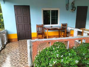 a house with a table and chairs and a door at Lanta Blue House in Ko Lanta
