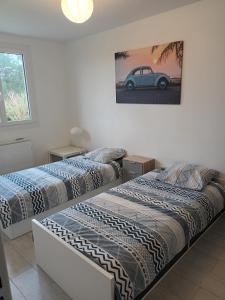 two beds in a room with a car on the wall at Ty Bihan in Crozon