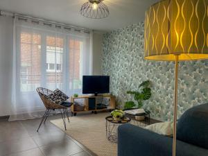 a living room with a couch and a tv at Au Puits Saint Josse - Centre Historique - WIFI in Arras