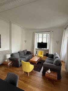a living room with two couches and a tv at Appartement entre lacs et montagnes in Saint-Claude