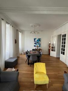a living room with a yellow chair and a table at Appartement entre lacs et montagnes in Saint-Claude