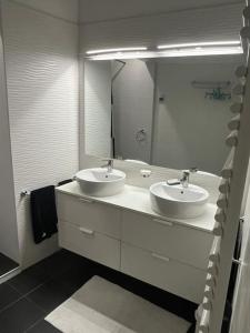 a bathroom with two sinks and a large mirror at Appartement entre lacs et montagnes in Saint-Claude