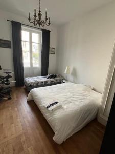 a bedroom with a large white bed and a window at Appartement entre lacs et montagnes in Saint-Claude